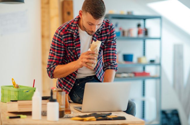 Man Making the Health Mistake of Standing While Eating at Computer | Vitacost.com/blog