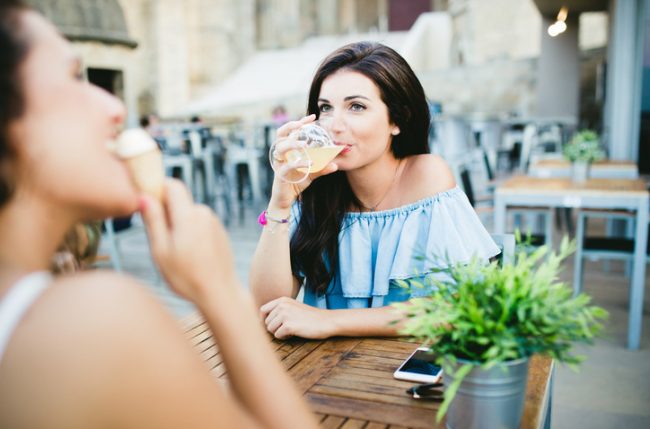 9 Dining Out Hacks for Healthier Summer Eating  Women Enjoying Refreshing Drink & Ice Cream While Dining Out at Summer Cafe | Vitacost.com/blog