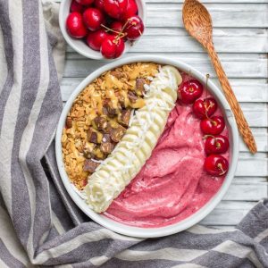Bowl of Beetroot Banana Ice Cream on White Wood with Gray Towel, Cherries & Wood Spoon | Vitacost.com/blog