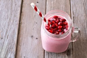 Pomegranate-Banana Protein Smoothie in Mason Jar Garnished with Pomegranate Seeds | Vitacost.com/Blog