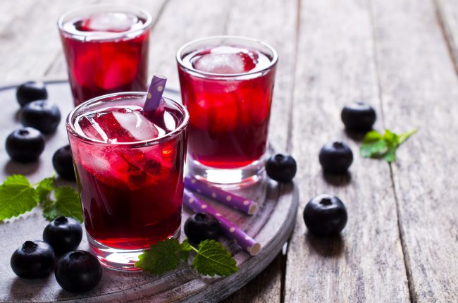 Get the Benefits of Berries with Blueberry Iced Tea on Wood Table with Straws | Vitacost.com/blog