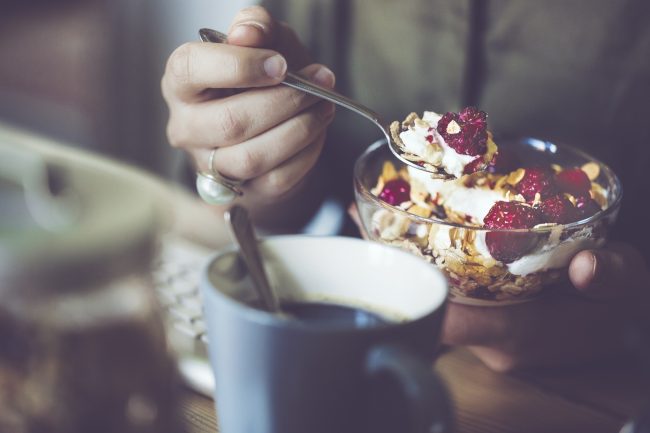Woman Eating Yogurt Breakfast with Coffee Wonders if This Lead to Fast Metabolism | Vitacost.com/blog