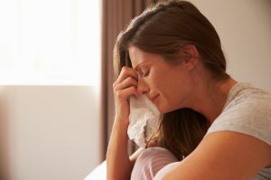 Woman Experiencing the Benefits of Crying Wiping Tears with Tissue | Vitacost.com/blog