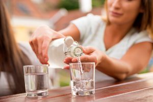 Woman Pouring Alkaline Water into Glasses | Vitacost.com/Blog