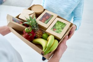 Home-Delivered Meal Kit Being Accepted by Woman at Door | Vitacost.com/blog