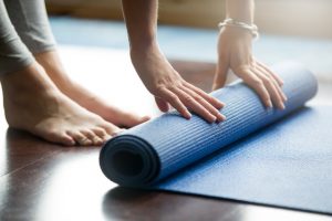 College Student Unrolling Mat to Work Out in Dorm Room | Vitacost.com/Blog