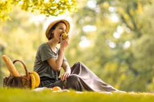 Woman Enjoying Picnic Lunch in Park After Taking Supplements to Help Digestion | Vitacost.com/blog