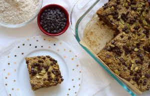 Healthy Zucchini Squares Recipe with 1 Square on White Plate & Bowl of Chocolate Chips for Topping | Vitacost.com/blog