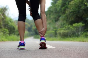 Running Woman With Muscle Cramps Paused in Road to Grip Leg in Pain | Vitacost.com/blog