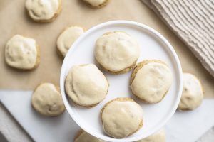 4 Healthy Pumpkin Iced Cookies on Pie Stand with More on Parchment Paper in Background | Vitacost.com/blog