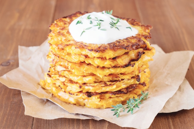 Stack of Butternut Squash Fritters with Thyme & Sour Cream on Napkins on Wood Table | Vitaocst.com/blog
