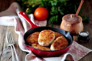 Pan-Fried Coconut Oil Chicken Recipe in Cast Iron Skillet Sitting on a Kitchen Towel | Vitacost.com/blog