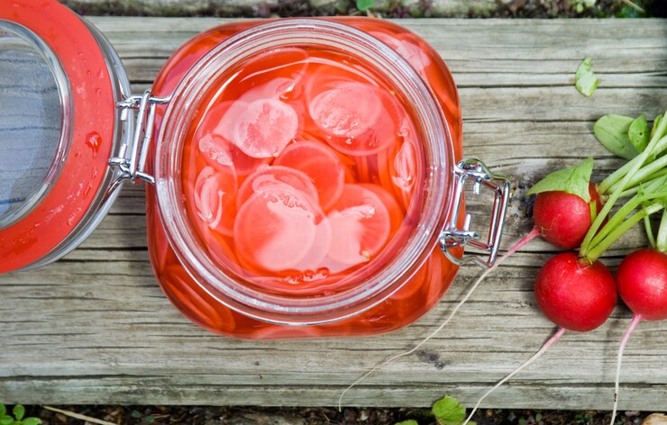 The Vegan Guide to Making Quick Pickles Homemade Pickled Radishes in Glass Jar on Wood Surface | Vitacost.com/Blog