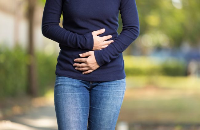 Woman With Stomach Growling Holding Abdomen in Embarrassment | Vitacost.com/blog