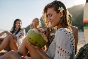 Woman Drinking Coconut Water out of Coconut Using Straw | Vitacost.com/Blog