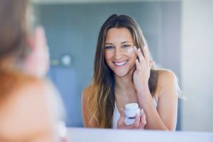 Woman Applying All-Natural Face Lotion in Mirror | Vitacost.com/Blog