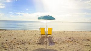 ALT= Two Chairs & Umbrella Sit on the Sandy Beach of the Healthiest City in America – What is It? | Vitacost.com/blog