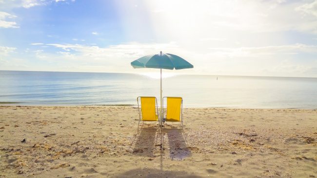 ALT= Two Chairs & Umbrella Sit on the Sandy Beach of the Healthiest City in America – What is It? | Vitacost.com/blog
