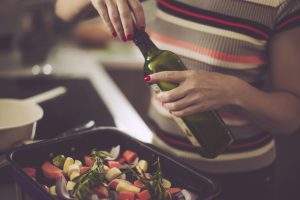 Woman Opening Olive Oil to Roast Veggies & Make Healthy Thanksgiving Recipes | Vitacost.com/blog