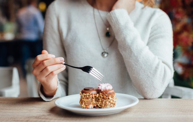 Woman Worried About Food Portion Sizes Eating Hesitating to Eat Slice of Cake | Vitacost.com/blog