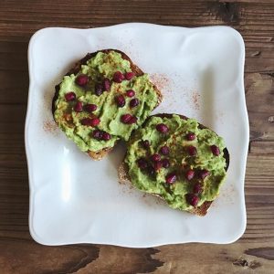 2 Slices of Toast with Tandoori Avocado Spread Topped with Pomegranate Seeds on White Plate | Vitacost.com/blog