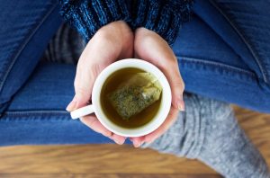 Woman Enjoying Health Benefits of Tea Sitting on Floor with Mug in Hands | Vitacost.com/blog