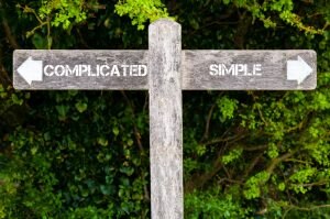 Wooden Sign Pointing Toward Complicated Path and Simple Path Depicting Minimalism | Vitacost.com/Blog
