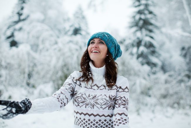 Happy Woman in Blue Hat and White Sweater in Snowy Landscape | Vitacost.com/blog