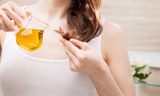 Woman Following Natural Hair Care Tips Applying Oil to Split Ends | Vitacost Blog