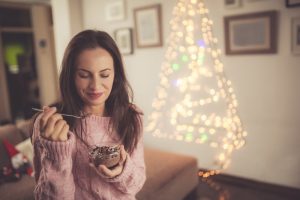 Woman Enjoying Healthy Snacks in Holiday-Decorated Living Room | Vitacost.com/blog