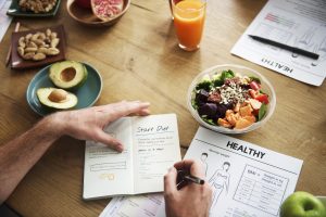 Person at Table Setting New Year’s Resolution Should Avoid These Top 5 Diet Mistakes | Vitacost.com/blog
