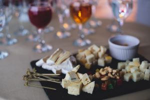 A Platter of Cheeses on Party Table with Wine Glasses Should Be Put Away to Prevent Foodborne Illness | Vitacost.com/blog