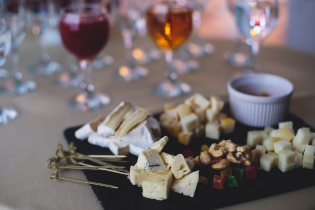 A Platter of Cheeses on Party Table with Wine Glasses Should Be Put Away to Prevent Foodborne Illness | Vitacost.com/blog