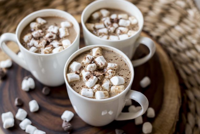 Vegan Gingerbread Hot Chocolate Side View of 3 White Mugs Filled with Vegan Gingerbread Hot Chocolate & Mini Marshmallows on Wood Plank | Vitacost.com/blog