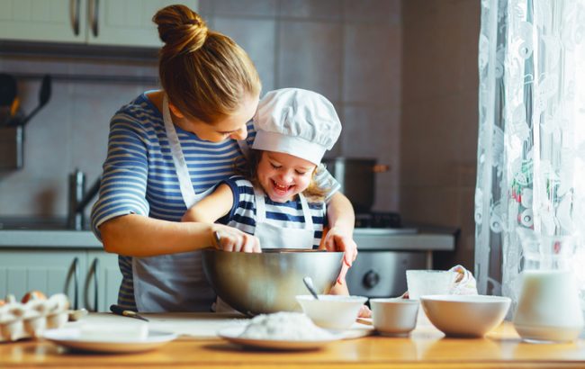 Woman Following Tips to Boost Your Mood Cooking a Healthy Meal with Her Child | Vitacost.com/blog