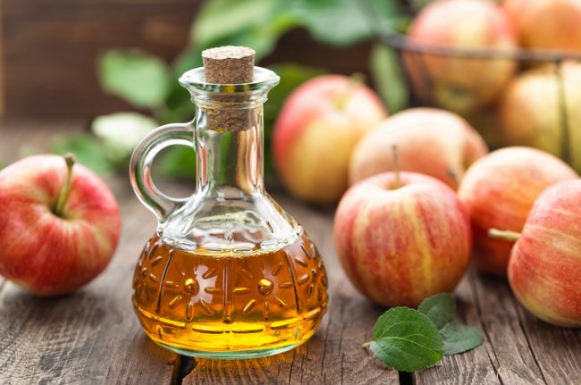 Apple Cider Vinegar in Glass Jar on Table Full of Apples  | Vitacost.com/blog