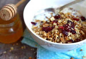Easy Granola with Cranberries in a White Bowl with Honey | Vitacost.com/blog