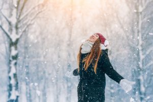 Young Woman Looking Up and Smiling in the Snow | Vitacost.com/blog