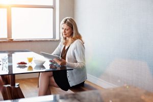 Woman at Breakfast Table with OJ, Enjoys a Menopause Diet Rich in Omegas, Vitamin D, Calcium & More | Vitacost.com/blog