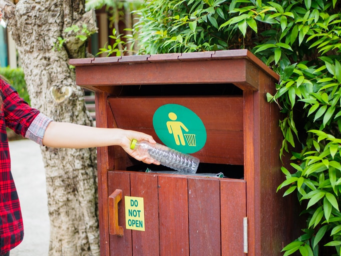 Hand Placing Plastic Water Bottle in Recycling Receptacle | Vitacost.com/Blog