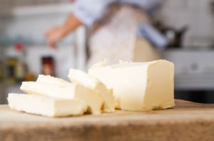 Sliced Sticks of Butter on Wooden Cutting Board as Example of Dietary Fats | Vitacost.com./blog