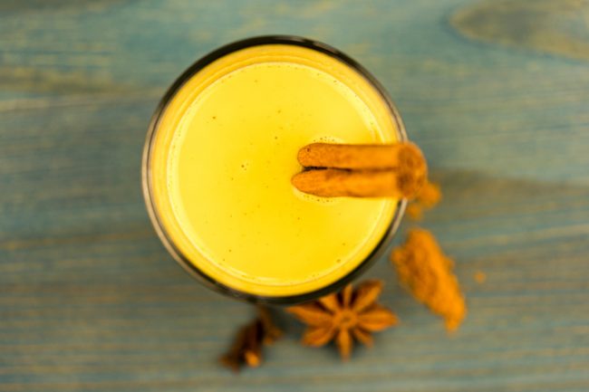 One of Turmeric Uses as Frothy Golden Milk Drink Garnished With Cinnamon Sticks | Vitacost.com/blog