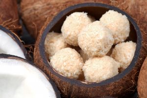 Keto Fat Bomb Balls Made with Maca & Covered in Coconut Sit Inside a Hollowed-Out Coconut #recipe | Vitacost.com/blog