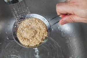 Gluten-Free Pseudo-Grain Quinoa Being Rinsed in Strainer Under Faucet | Vitacost.com/blog