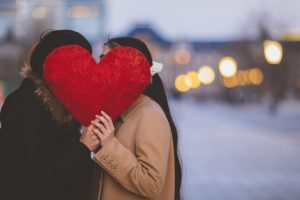 Valentine’s Ideas: Supplements for Heart Health are Celebrated with a Couple Holding a Heart Pillow in Front of Their Faces | Vitacost.com/blog