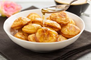 A Bowl of Small Cauliflower Pancakes Being Drizzled with Honey | Vitacost.com/blog