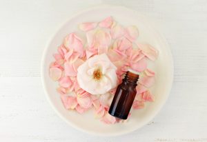 Small Amber Bottle Filled with Homemade Rosewater in Dish with Rose Petals | Vitacost.com/Blog