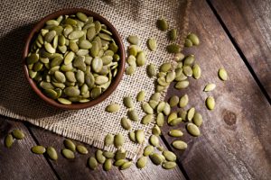 Bowl of Pumpkin Seeds on Wooden Tab;e to Represent One of Best Snacks for Keto Dieters | Vitacost.com/blog