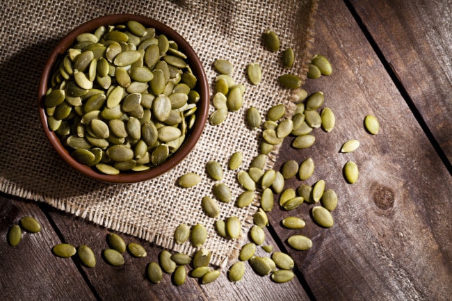 Bowl of Pumpkin Seeds on Wooden Tab;e to Represent One of Best Snacks for Keto Dieters | Vitacost.com/blog