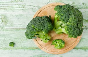 Two Heads of Fresh Broccoli on Cutting Board Being Prepared for Cancer Prevention Diet | Vitacost.com/blog